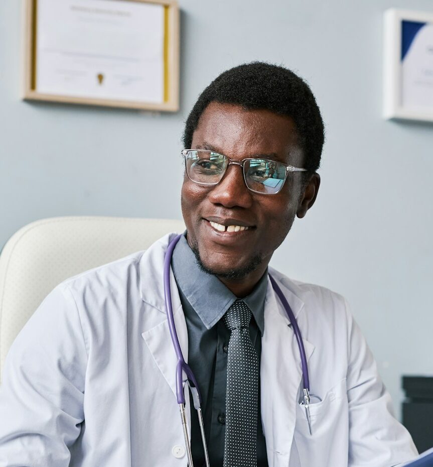 Smiling black doctor consulting female doctor in clinic